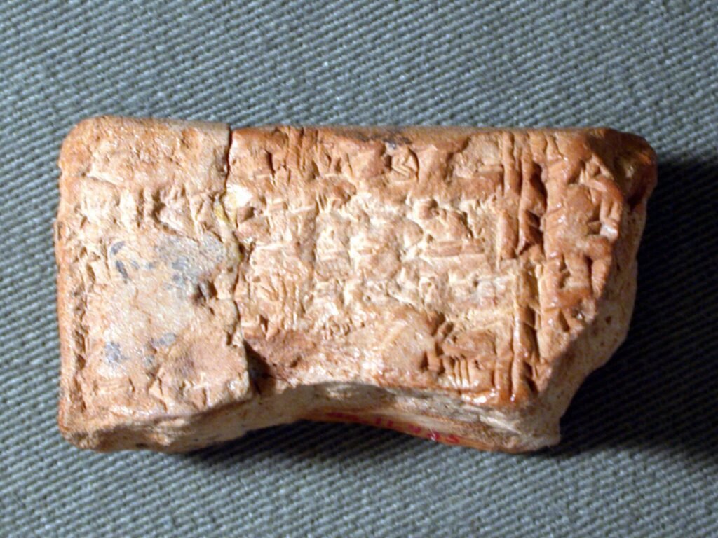 Ancient clay school exercise tablet covered in wedge-shaped cuneiform writing