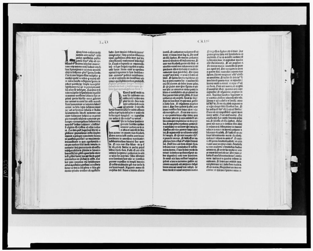 An open Gutenberg Bible showing two pages of dense black Latin type in two columns